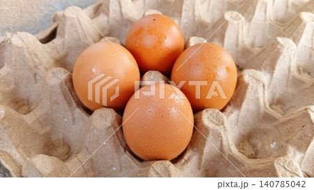Close-up of four fresh uncooked eggs in a tray or egg carton. Close-up of four fresh uncooked eggs in a tray or egg carton. 140785042