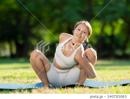 Girl enjoying outdoor yoga practice in green summer park Girl enjoying outdoor yoga practice in green summer park 140785063