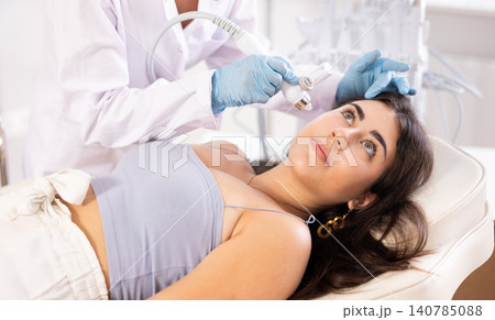 Beauty procedure to brunette girl (atomizing pen) 140785088