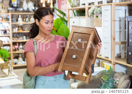 Portrait of woman choosing chest of drawers in furniture store 140785125