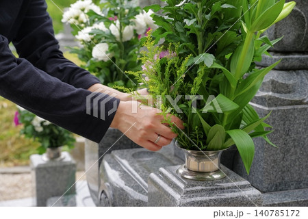 お墓参りで花立に供花する女性 お墓参りで花立に供花する女性 140785172