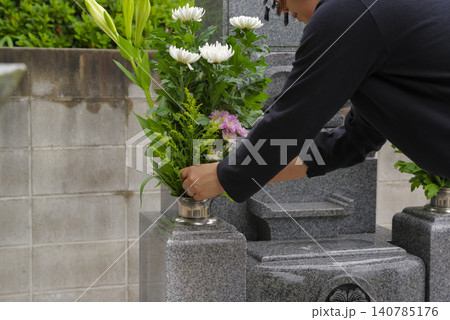 お墓参りで花立に供花する女性 お墓参りで花立に供花する女性 140785176