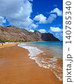 A golden dream beach in Tenerife, shimmering between turquoise waters and majestic mountain scenery. 140785340
