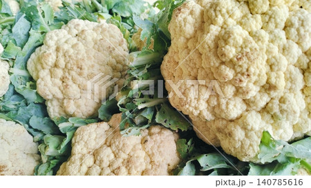 Fresh Raw Cauliflower Heads with Green Leaves on Market Stall 140785616