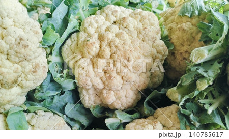 Fresh Raw Cauliflower Heads with Green Leaves on Market Stall Fresh Raw Cauliflower Heads with Green Leaves on Market Stall 140785617