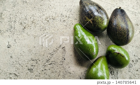 Fresh Whole Green and Ripe Avocados on Concrete Background Fresh Whole Green and Ripe Avocados on Concrete Background 140785641