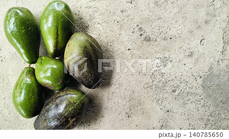 Fresh Whole Green and Ripe Avocados on Concrete Background Fresh Whole Green and Ripe Avocados on Concrete Background 140785650