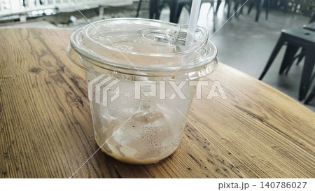 Empty Iced Coffee Takeaway Plastic Cups with Leftover Ice Cubes Empty Iced Coffee Takeaway Plastic Cups with Leftover Ice Cubes 140786027
