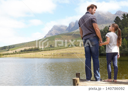 Father, daughter and holding hands with pier by a lake, bonding in nature with holiday, travel and family time. Love, support and trust, man and young girl outdoor for adventure and fresh air 140786092