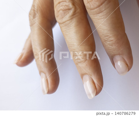 A close view of female fingers with unpolished nails revealing a gap at the cuticles. This highlights the need for timely nail care and a trip to the salon for maintenance. A close view of female fingers with unpolished nails revealing a gap at the cuticles. This highlights the need for timely nail care and a trip to the salon for maintenance. 140786279