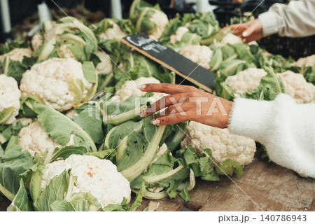Fresh cauliflower heads rest on a rustic wooden table 140786943