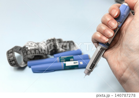 Ozempic injection pen in patient hand for diabetes and obesity treatment. Ozempic injection pen in patient hand for diabetes and obesity treatment. 140787278