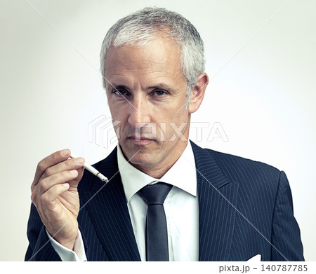 Portrait, mature and businessman smoking cigarette with salesman in studio isolated on a gray background. Face, suit and serious man with tobacco, ceo and manager with vintage fashion in Australia 140787785