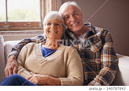 Senior couple, happy and portrait in sofa with hug, love and connection in living room for retirement. Elderly woman, old man and embrace on lounge couch with pride, care and smile in apartment 140787842