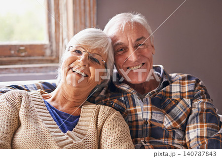 Senior couple, smile and portrait in sofa with hug, love and connection in living room for retirement. Elderly woman, old man and embrace on lounge lounge with pride, care and happy in apartment 140787843