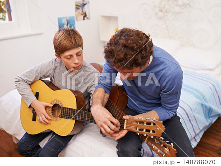 Guitar, teacher and learning music with child in lesson for development of skill on instrument. Playing, practice and man helping musician kid in education with advice as mentor in acoustic sound 140788070