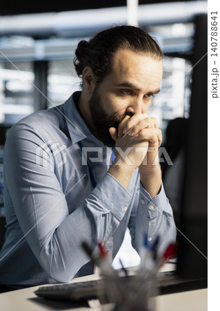 Worried server room technician reviews a diagnostic report about critical hardware malfunction and uptime risk. Worried server room technician reviews a diagnostic report about critical hardware malfunction and uptime risk. 140788641