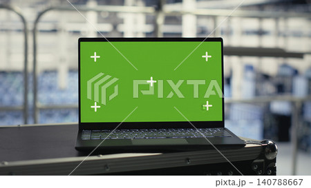 Technology specialist uses an isolated screen laptop in a server room for editable AI infrastructure review. Technology specialist uses an isolated screen laptop in a server room for editable AI infrastructure review. 140788667