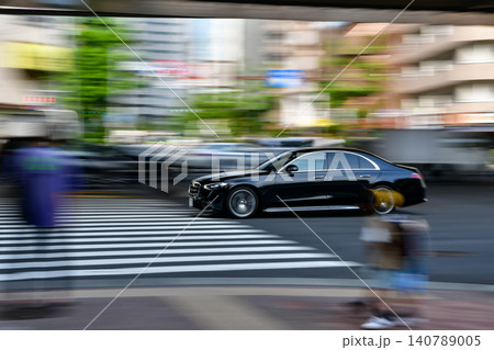 朝の通勤時間帯を走る黒い高級車の流し撮り写真 140789005