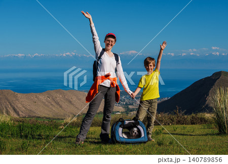 Happy hikers mom and son with dog on top of the mountain Happy hikers mom and son with dog on top of the mountain 140789856