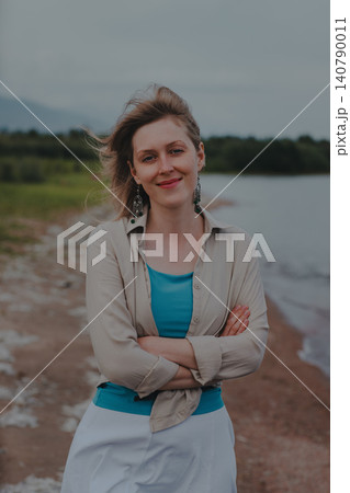 Portrait of beautiful smiling woman on the beach at windy day 140790011