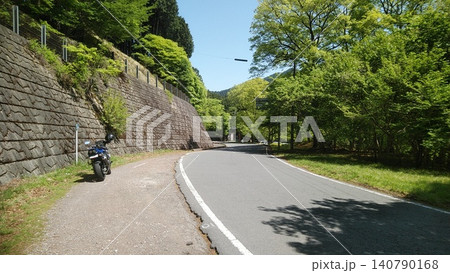 新緑に包まれた山道でバイクを停め、景色を楽しむツーリング。 新緑に包まれた山道でバイクを停め、景色を楽しむツーリング。 140790168