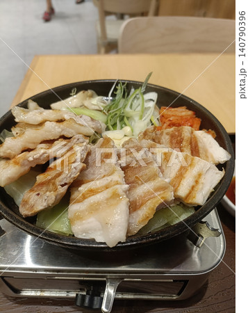 Grilled pork, kimchi, onion, skillet Korean barbecue meal on portable stove 140790396