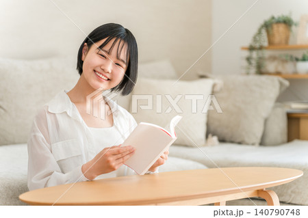リビングでスキマ時間に読書をする中学生,高校生の女の子 リビングでスキマ時間に読書をする中学生,高校生の女の子 140790748
