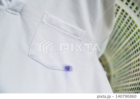 White cotton shirt stained with blue or purple ballpoint pen ink. Cleaning, washing problem, and housework accident concept. White cotton shirt stained with blue or purple ballpoint pen ink. Cleaning, washing problem, and housework accident concept. 140790860