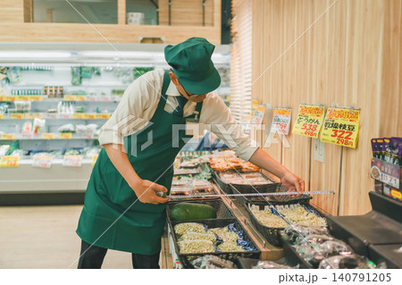 スーパーで売り場の奥行きを計測する男性店員 140791205