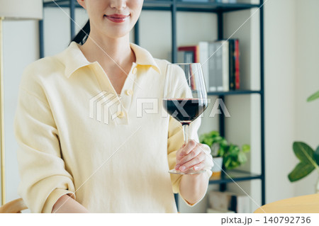 家で赤ワインを飲む若い女性の手元 140792736