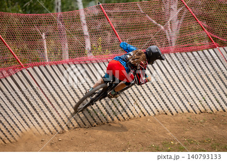 Woman downhill racer rides turn Woman downhill racer rides turn 140793133