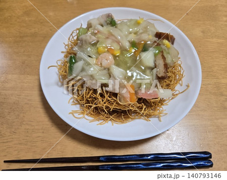 家庭で作る具だくさんであつあつの皿うどん(あんかけ揚げ麺)お箸添え 家庭で作る具だくさんであつあつの皿うどん(あんかけ揚げ麺)お箸添え 140793146
