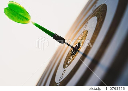 Dart hitting bullseye on target in a dartboard game 140793326