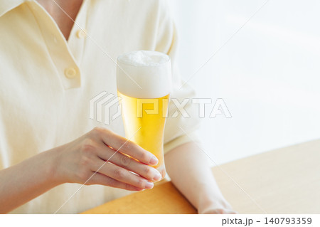 家でビールを飲む若い女性の手元 140793359