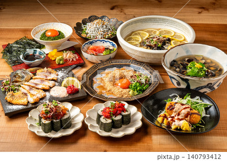 居酒屋のテーブルに並ぶ豪華な和風一品料理と海鮮メニューの数々 140793412