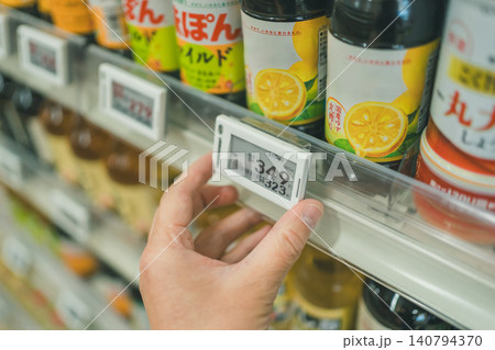 スーパーの調味料棚で電子棚札を設置する手元 スーパーの調味料棚で電子棚札を設置する手元 140794370