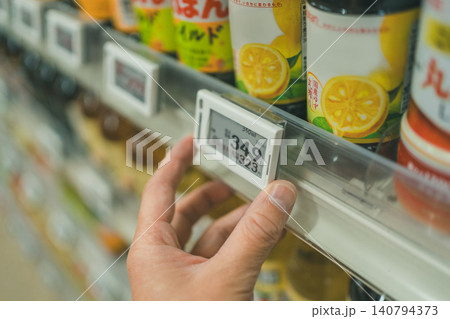 調味料棚の電子棚札を操作するスーパー店員の手元 調味料棚の電子棚札を操作するスーパー店員の手元 140794373