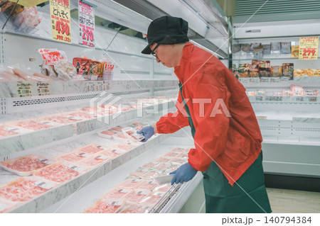 スーパーマーケットの精肉売り場で豚肉を陳列する男性店員 スーパーマーケットの精肉売り場で豚肉を陳列する男性店員 140794384
