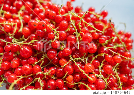 A pile of fresh, glowing red currant berries with a bright, slightly overexposed background. Perfect representation of summer abundance and healthy lifestyle. Macro view of raw redcurrant crop rich in A pile of fresh, glowing red currant berries with a bright, slightly overexposed background. Perfect representation of summer abundance and healthy lifestyle. Macro view of raw redcurrant crop rich in 140794645