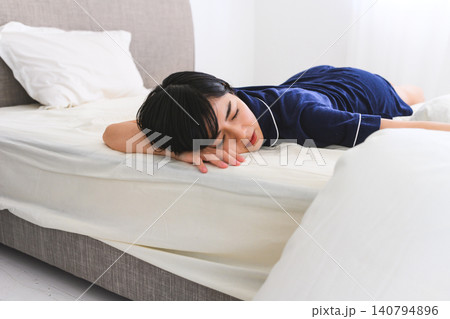 ベッドで横たわり眠る疲れた女性 ベッドで横たわり眠る疲れた女性 140794896