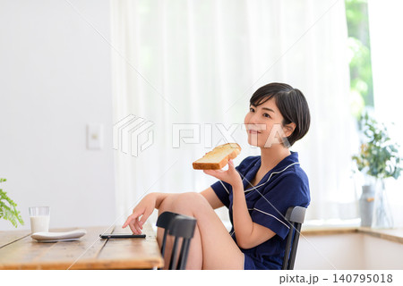 朝食中に微笑む若い女性 140795018