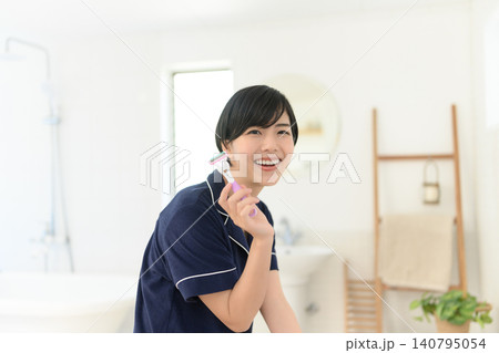 カミソリを持って笑顔を見せる女性 140795054