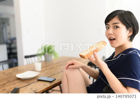 朝食のトーストを手に驚く表情の女性 朝食のトーストを手に驚く表情の女性 140795071