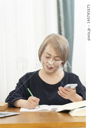 スマホで英会話の学習をするシニア女性 スマホで英会話の学習をするシニア女性 140795875
