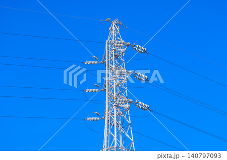 鮮やかな青空にそびえ立つ真っ白な送電鉄塔と幾筋もの電線 鮮やかな青空にそびえ立つ真っ白な送電鉄塔と幾筋もの電線 140797093