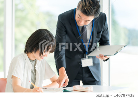 塾・学童で勉強・学校で授業・夏期講習をする小学生の子供と講師,教師の男性(教育) 塾・学童で勉強・学校で授業・夏期講習をする小学生の子供と講師,教師の男性(教育) 140797438