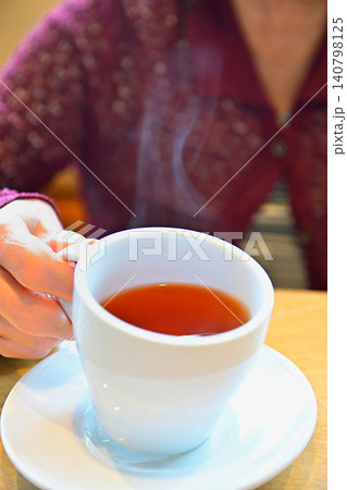 湯気のでるいれたての紅茶を飲む女性 湯気のでるいれたての紅茶を飲む女性 140798125