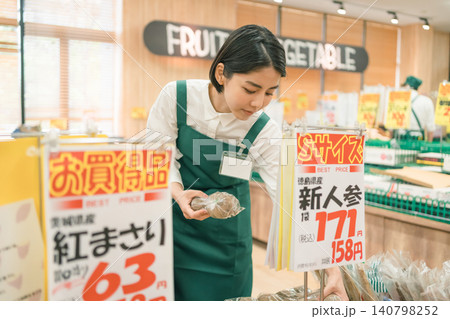スーパーマーケットの野菜売り場で女性スタッフが作業している スーパーマーケットの野菜売り場で女性スタッフが作業している 140798252