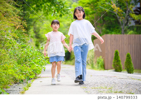 緑道を手をつないで歩く姉妹 140799333